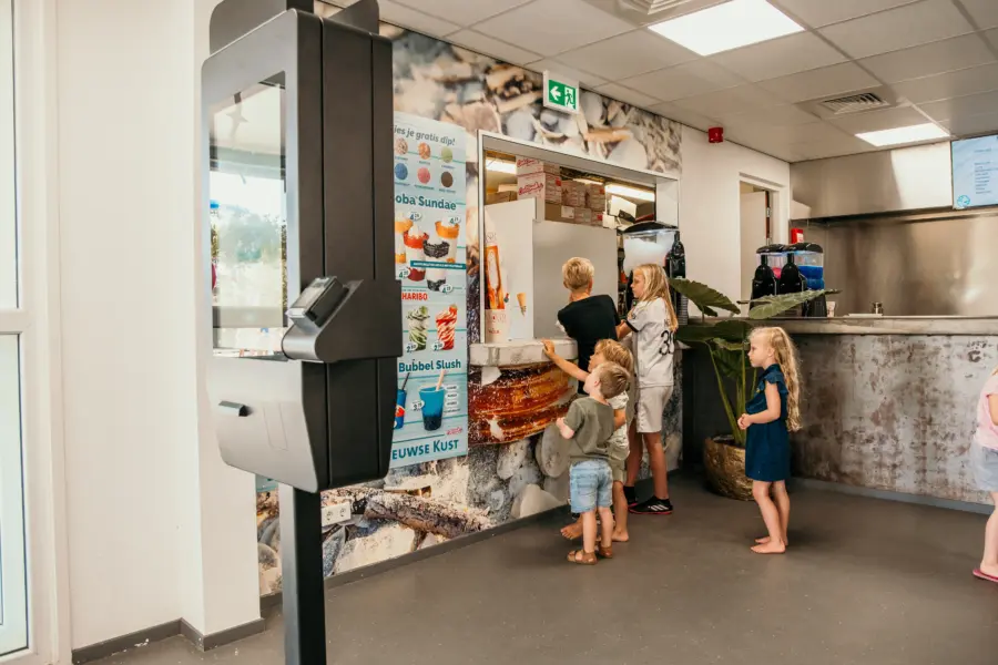 Met grote ogen kiezen uit alle lekkernijen – smullen begint hier bij de gezellige snackbar van Strandpark De Zeeuwse Kust