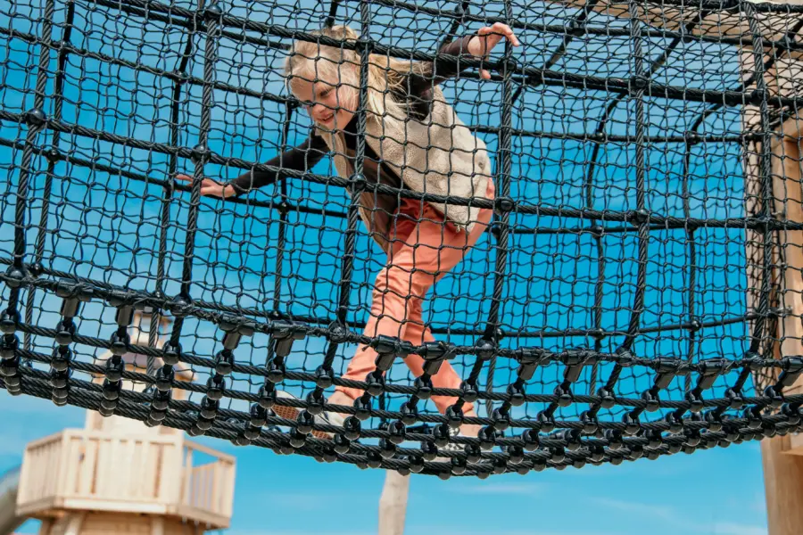 Meisje rent door het nieuwe speeltoestel lekker dichtbij het strand